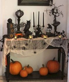 a table topped with lots of pumpkins next to a black and white fireplace mantel