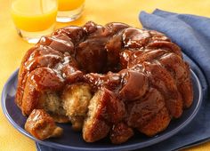 a bundt cake on a blue plate next to orange juice