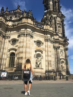 a woman standing in front of an old building