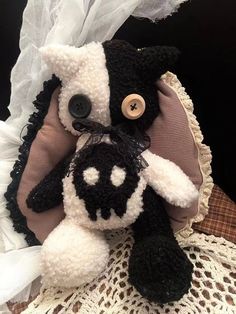 a black and white stuffed animal sitting on top of a doily