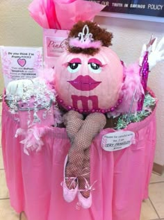 a pink pumpkin with a tiara sitting on top of it's head and legs