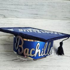 a blue graduation cap with the word bachelor written on it and tasseled by a black tassel