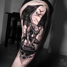 a man's leg with a bat and skull tattoo on it