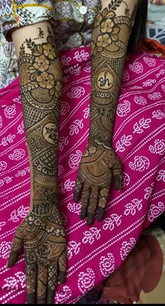 the hands and feet of a woman with henna tattoos on their arms, both covered in