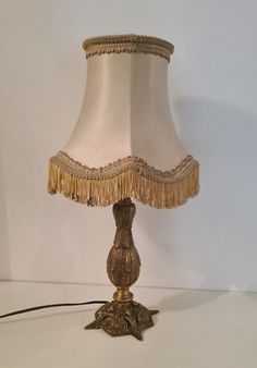 a lamp that is on top of a white table with a black cord attached to it