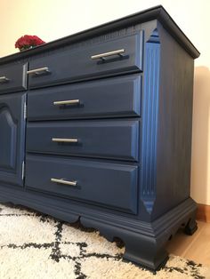 a blue dresser sitting on top of a white rug