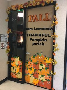 a door decorated with pumpkins and leaves for a fall themed classroom door decorating contest