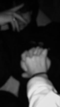 a black and white photo of someone holding their hand out to another person's arm