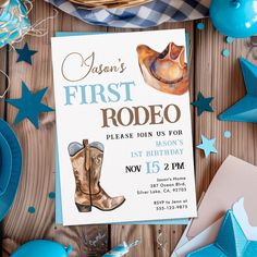 a first rodeo birthday party with cowboy boots and blue decorations on a wooden table top