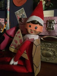 an elf is sitting on top of a desk next to a suitcase and other items