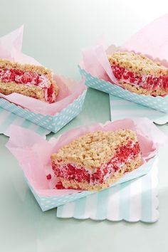 four strawberry crumb bars sitting on top of pink paper