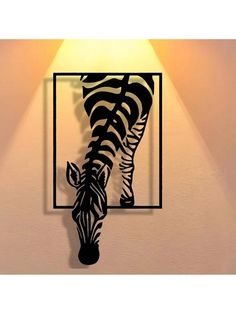 a zebra is standing in front of a light on the wall with it's head down