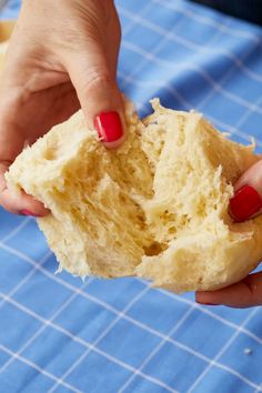 a person holding a half eaten doughnut on a blue tablecloth with white squares