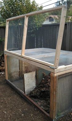 an outdoor chicken coop in the middle of a yard with wood and wire around it