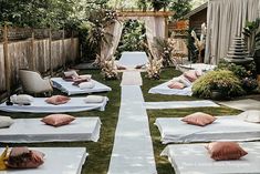 there are many mattresses lined up on the grass in front of an outdoor area