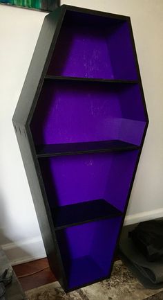 a purple shelf sitting in the corner of a room