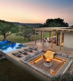 an aerial view of a house with a pool in the middle and patio furniture around it