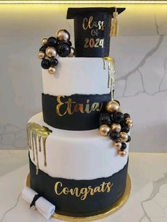 a graduation cake decorated with black and gold decorations