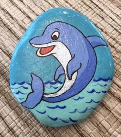 a painted rock with a dolphin on it