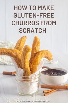 churros in a glass jar with cinnamon sticks and dipping sauce on the side