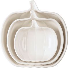 three white pumpkin shaped dishes stacked on top of each other in front of a white background