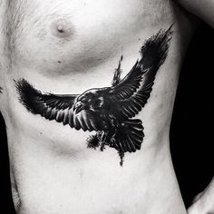 a black and white photo of a man's chest with an eagle tattoo on it