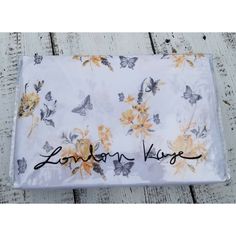 a white table cloth with yellow flowers and butterflies on it that says london kree