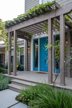 a blue front door sits on the side of a house with steps leading up to it