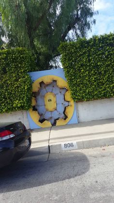 a black car parked next to a blue and yellow sign