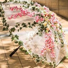 an umbrella decorated with flowers on the sidewalk