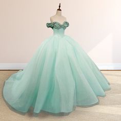 Embrace timeless elegance with this Mint Green Off-the-Shoulder Tulle Ball Gown Quinceanera Dress. The soft mint green hue exudes freshness and sophistication, while the flowing tulle fabric adds an ethereal charm to your look. The off-the-shoulder neckline highlights your collarbones beautifully, combining grace and allure. The sleeveless design keeps the gown effortlessly classic, while the corset back ensures a tailored fit for a stunning silhouette. The pleated embellishments add depth and t Tulle Quinceanera Dress With Sweetheart Neckline For Banquet, Quinceanera Tulle Dress With Sweetheart Neckline For Banquet, Sweetheart Neckline Tulle Quinceanera Dress For Banquets, Fitted Green Tulle Quinceanera Dress, Green Quinceanera Dress With Fitted Bodice, Princess Organza Ball Gown For Banquet, Organza Floor-length Ball Gown For Quinceanera, Princess Style Organza Ball Gown For Banquet, Tulle Ball Gown Quinceanera Dress For Banquet