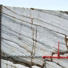 a large rock with chains on it and a red object attached to the side of it