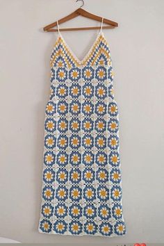 a blue and yellow dress hanging on a wall