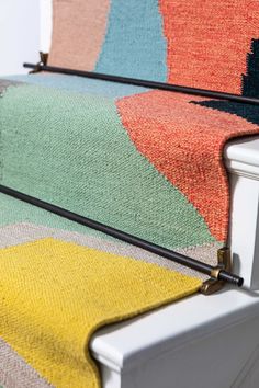 an upholstered bench with multicolored rugs on it's sides