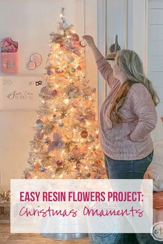 a woman decorating a christmas tree with the words easy resin flowers project on it