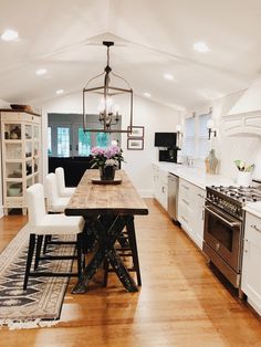 a kitchen with white cabinets and wooden floors