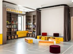 an empty library with bookshelves and stools on the floor in front of them