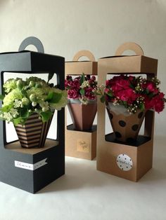 two boxes with flowers in them sitting on a table