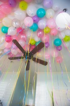 the ceiling is decorated with balloons, streamers and a clock on it's side