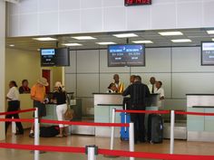 people waiting in line at an airport for their luggage