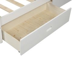 a white wooden bed frame with two drawers on the bottom and one drawer at the top