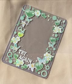 there is a photo frame with flowers and butterflies on it that says try again, again