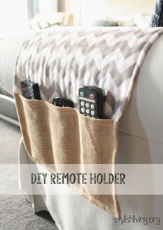 four remote controls are sitting in the pocket of a couch with a blanket on it