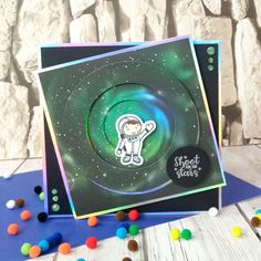 a card with an astronaut bear on the front and space in the back, surrounded by candy