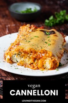 a white plate topped with lasagna covered in cheese and sauce on top of a wooden table