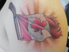 a canadian flag tattoo on the back of a woman's shoulder