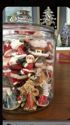 a glass jar filled with santa clause figurines