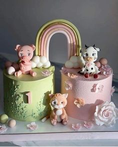 there are three cakes that have animals on the top one has a rainbow in the middle