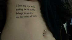 a woman with a tattoo on her stomach saying i love my mine nothing in the world belongs to me