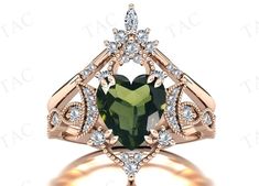 a heart shaped green tourmaline ring with diamonds on the sides and an openwork design